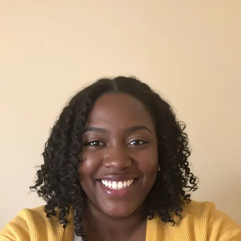 The original selfie: a smiling woman in a yellow cardigan